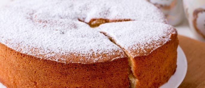 Close up of a Victoria sponge cake with icing sugar dusting.