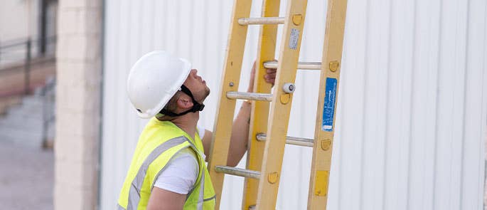 A person carrying out a ladder inspection