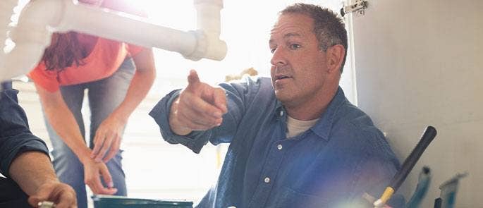 A plumber working at a house