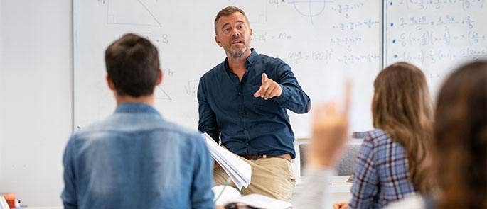 Teacher engaging students at the front of the classroom