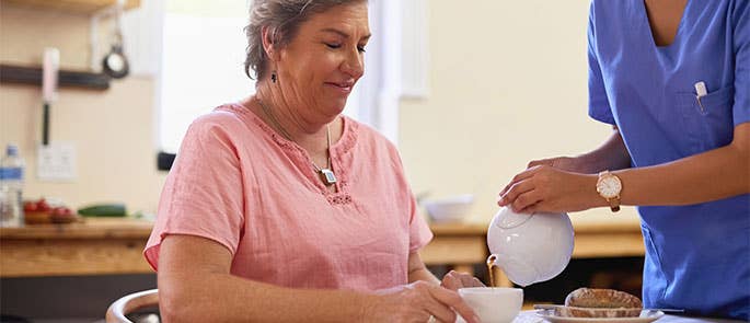 health and social care worker pouring tea for patient