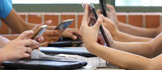 children using their mobile phones in school 