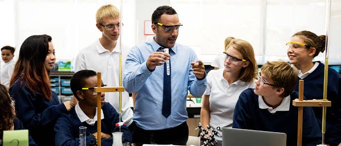 student working with a group of science students