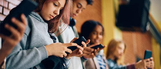 Teenagers using Snapchat on their mobile phones